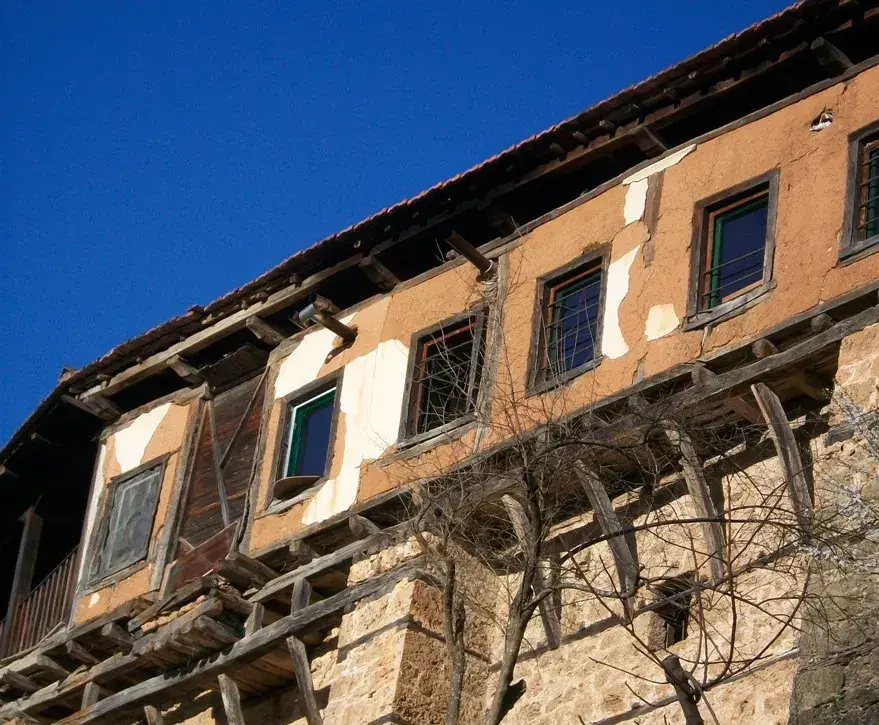 Η πτέρυγα των κελιών με τον ξύλινο εξώστη πάνω στο πέτρινο τείχος